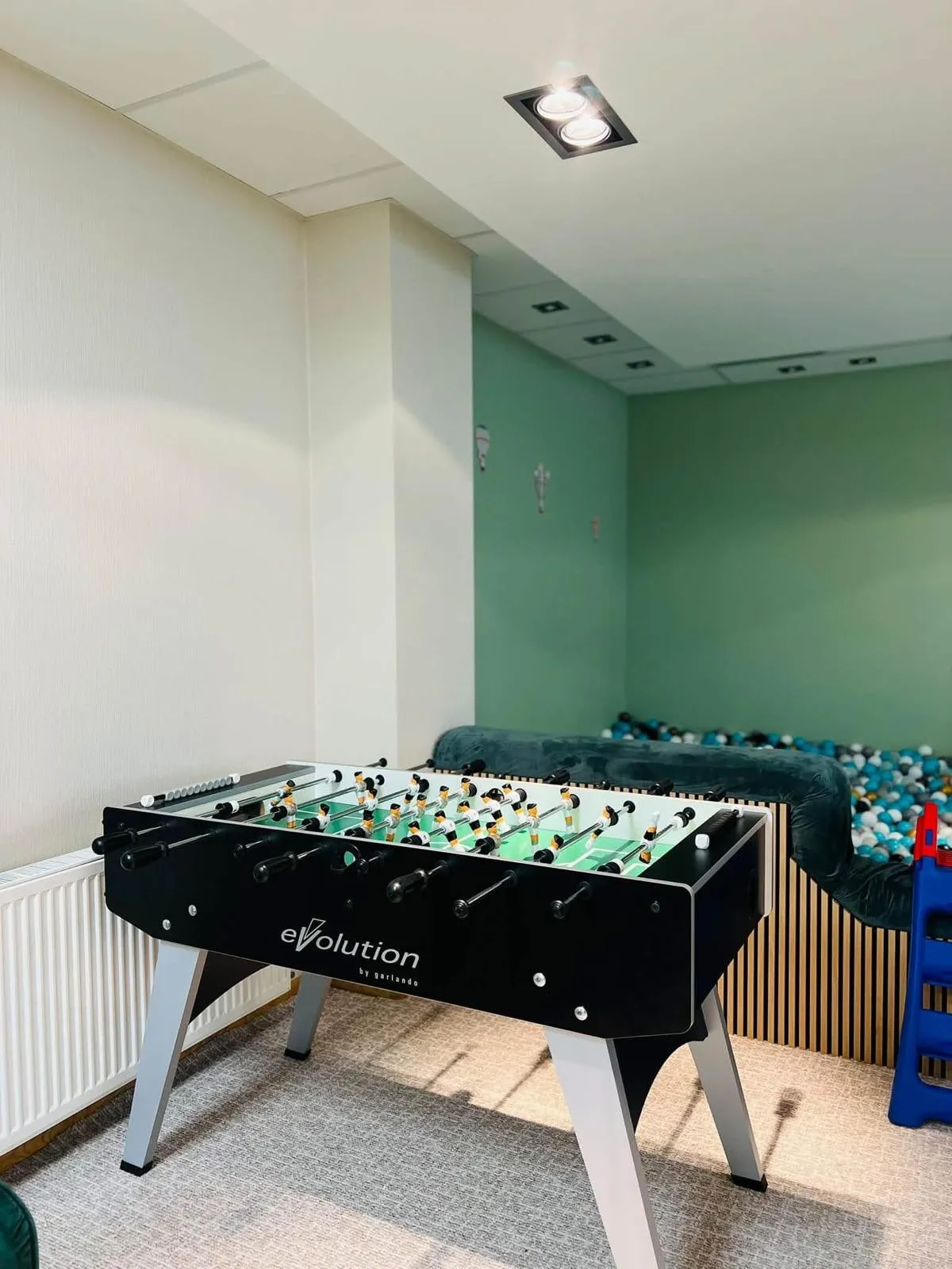 Galda futbola galds pie bumbu baseina zaļajā zonā